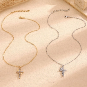 Detail view of gold and silver cross necklaces with micro-pave crystals and floral accents