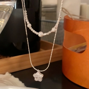 Close-up of elegant double-layered necklace with pearl beads and zircon star pendant