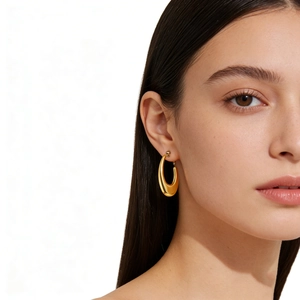 Polished gold hollow oval hoop earrings for women in minimalist stainless steel style