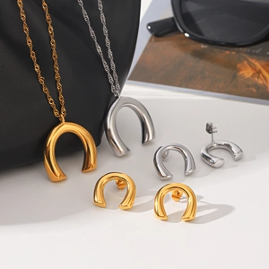Close-up of minimalist U-shape gold and silver necklace set with matching stud earrings