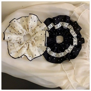 Detail of fabric polka dot scrunchies with elegant lace trim in black and white colors