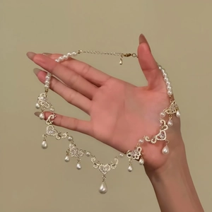 Vue détaillée d'un collier de perles en cœur vintage avec des pendentifs en strass brillants
