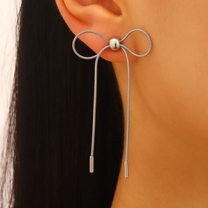 Detail of silver bow tassel earrings with snake chains and polished metal finish