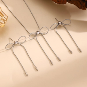 Detail eines silbernen Schmucksets mit Schleifendesign aus Schlangenkette und Ohrringen