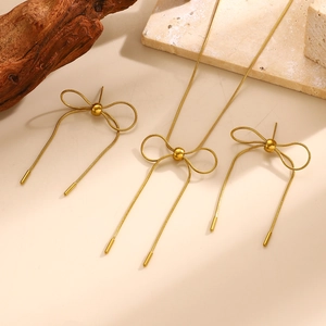 Details zum goldenen Schleifen-Schmuckset mit Kette und Ohrringen auf Steindekor