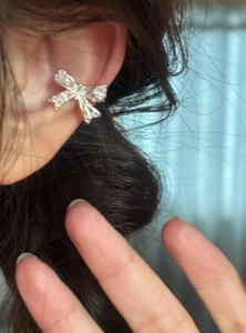 Vue détaillée d'un ear cuff nœud en zircon brillant porté sans perçage sur l'oreille.