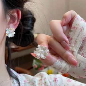 Detailed macro shot of elegant silver camellia flower earrings with intricate petal design