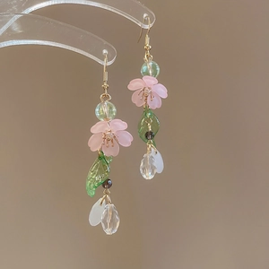 Detail view of sweet pink acrylic flower earrings with green leaf and crystal beads