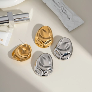 Detailed view of high-polish liquid metal geometric stud earrings in gold and silver finish