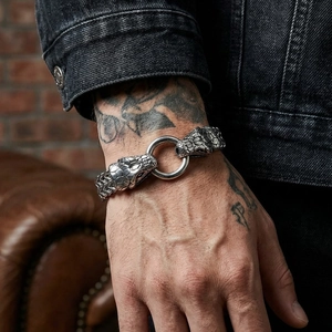 Close-up of vintage silver snake head bracelet on a tattooed wrist with industrial style