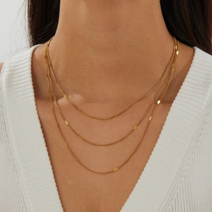 Close-up detail of three-layered gold-plated stainless steel chain necklace