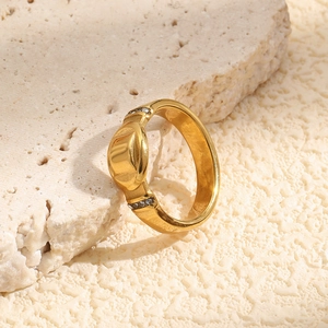 Close-up of 18K gold-plated stainless steel ring with oval convex design and stones