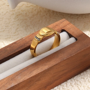 Detailed view of an 18K gold plated stainless steel ring with oval top and side stones.