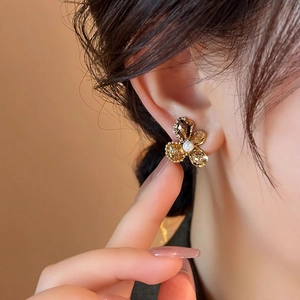 Close-up view of elegant flower stud earrings with glass petals and a central pearl accent.