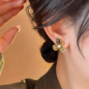 Elegant close-up view of a floral glass earring with pearl center worn by a model