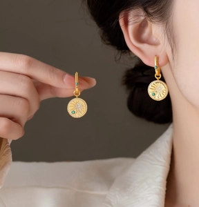 Close-up of vintage 18K gold plated round starburst earrings with turquoise