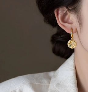Detailed view of 18K gold plated round star earrings with turquoise and zirconia accents