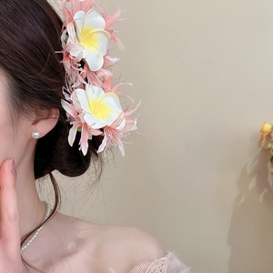 Close-up detail view of a sweet mesh fabric flower hair clip with pearls worn by a model