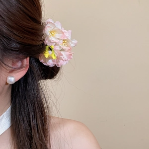 Detailed close-up showing the pink mesh fabric flower hair clip worn on model's dark hair.