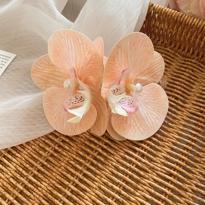 Sweet peach orchid fabric hair clip with center pearl detail for elegant feminine styling