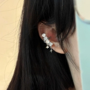 Detailed view of a sparkling geometric zircon ear cuff featuring a dangling star charm