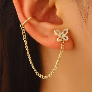 Exquisite detail of gold butterfly stud earring connected to ear cuff by delicate chain