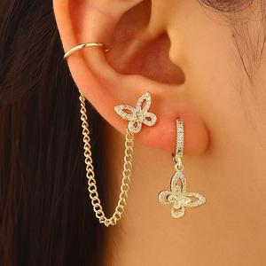 Detailed view of gold-toned butterfly earrings with zircon inlay and chain ear cuff