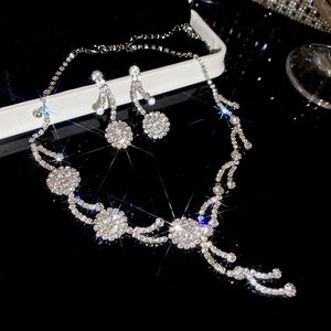 Detailed macro view of sparkling rhinestone flower necklace and earring set on black base