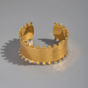 Detailed macro shot of vintage 18K gold-plated stainless steel wavy wide open cuff bracelet