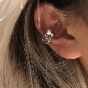 Detailed close-up showing an elegant zircon and pearl ear cuff worn on a non-pierced ear