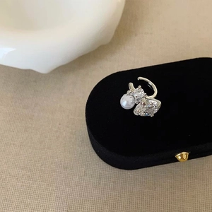 Elegant pearl and cubic zirconia ear cuff displayed on black velvet jewelry stand