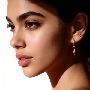 Detailansicht stilvoller goldener Blitzohrringe mit Pavé-Kristallen an einem Model.