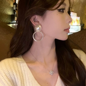 Primer plano de una modelo con elegantes pendientes de aro con perlas blancas para una cena