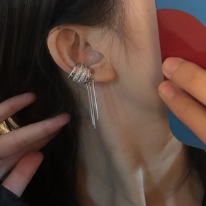 Close-up detail of a silver-colored wide multi-band ear cuff with long tassel chains on ear