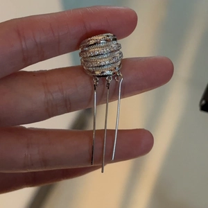 Macro view of silver tassel ear cuff featuring elegant rhinestone layers for non-pierced ears
