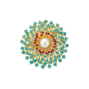 Exquise broche soleil plaquée or 18 carats avec perle centrale et billes turquoise.