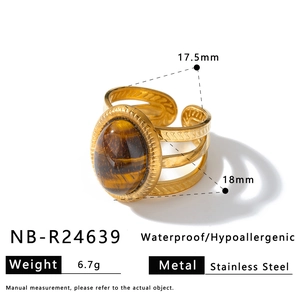 Macro detail of gold stainless steel ring with oval tiger eye stone and textured band