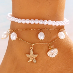 Vista de detalle de conjunto de tobilleras de playa con perlas y estrella de mar
