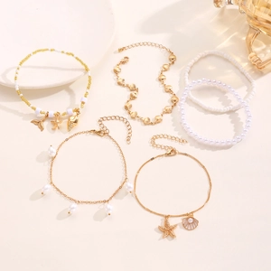 Vista detallada del conjunto de tobilleras con estrellas de mar, conchas y perlas finas