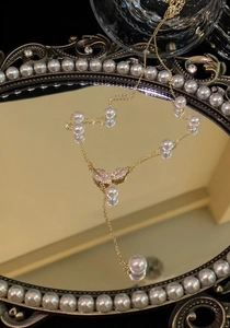 Detailed view of elegant 18k gold plated leaf necklace with pearls and zircons.