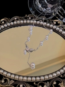 Close-up of a luxury 18k gold plated necklace featuring pearls and zircon leaf motifs.