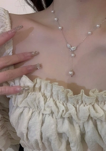 Elegant 18k gold plated necklace with zircon leaf motif and pearl drop on female model.