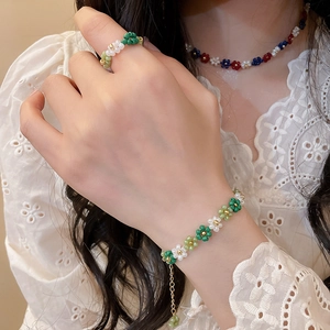Detailed view of handmade crystal beaded flower necklace bracelet and ring set on model