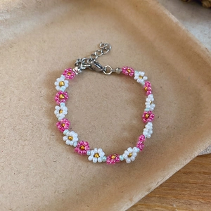 Detailed view of handmade beaded flower bracelet with pink and white crystal beads.