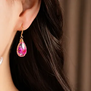 Elegant handmade resin teardrop earrings featuring pink dried flowers and gold hooks.