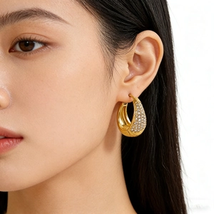 Boucles d'oreilles créoles semi-ovales en acier doré ornées de zircons blancs brillants