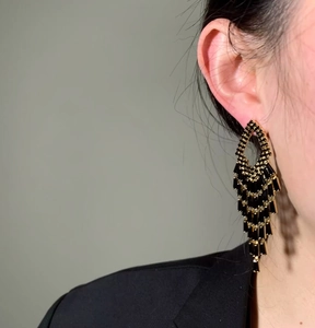 Elegant black zirconia baguette tassel earrings shown worn on an Asian model's ear