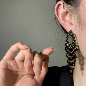 Elegant black rectangular crystal tassel earrings shown on ear for a glamorous look