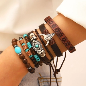 Detail of bohemian multilayer bracelet set with wood beads and bull head charm on wrist