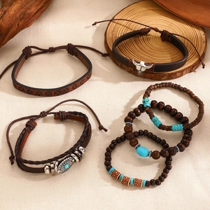 Detail of bohemian leather bracelets with turquoise beads and ox head charm on wood